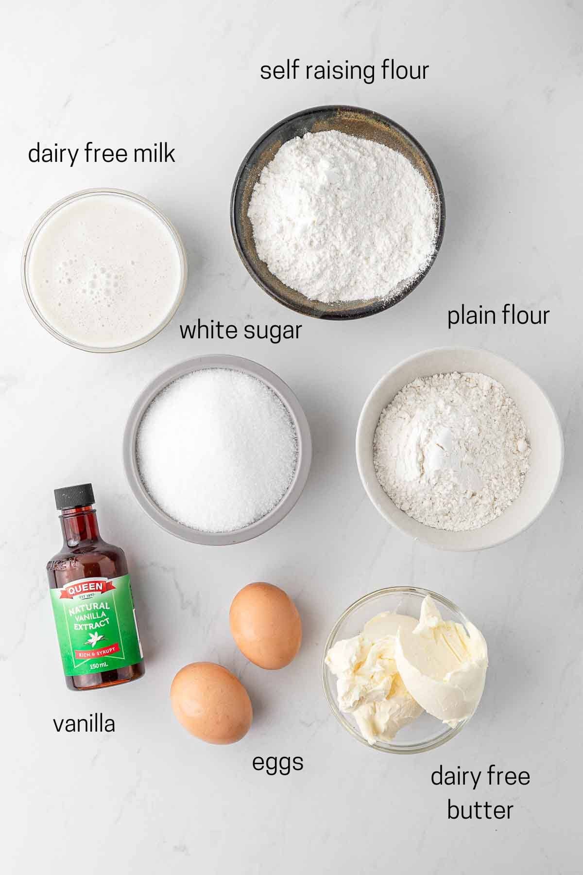 All ingredients needed for vanilla cupcakes laid out in bowls.