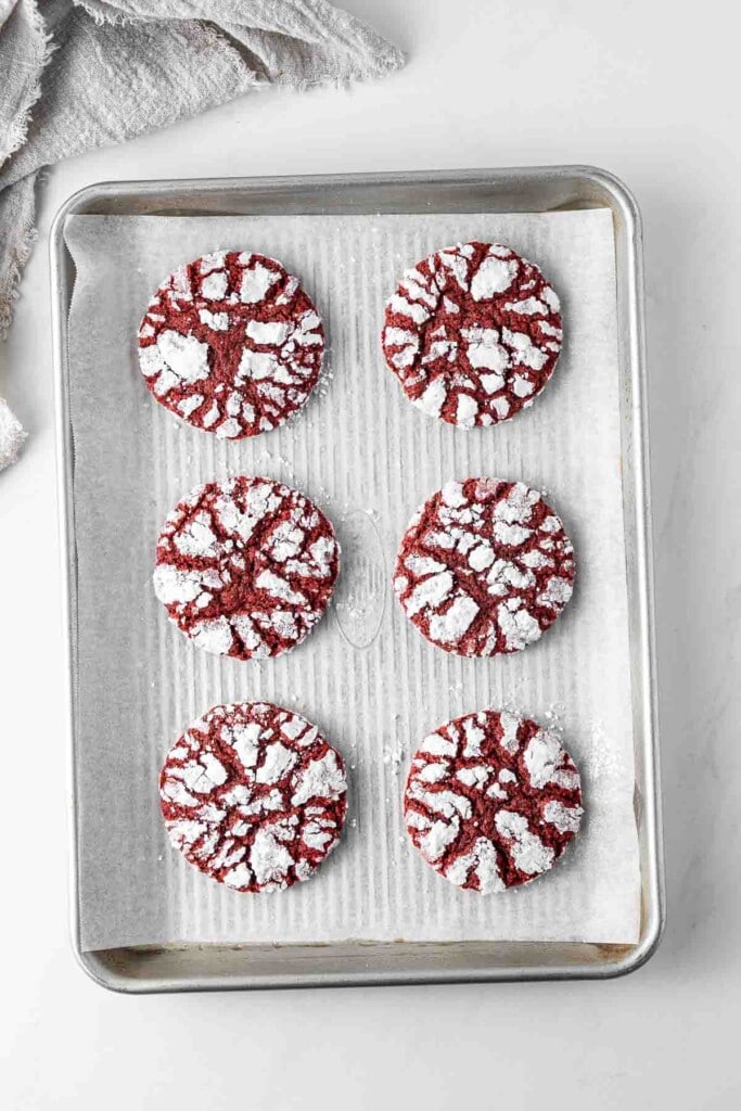 Freshly baked red velvet cookies on a baking tray.