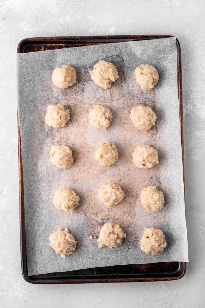 Chicken meatballs on a baking tray.
