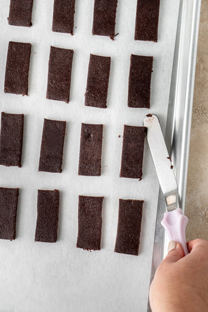 Placing the chocolate biscuits on a baking tray to bake.