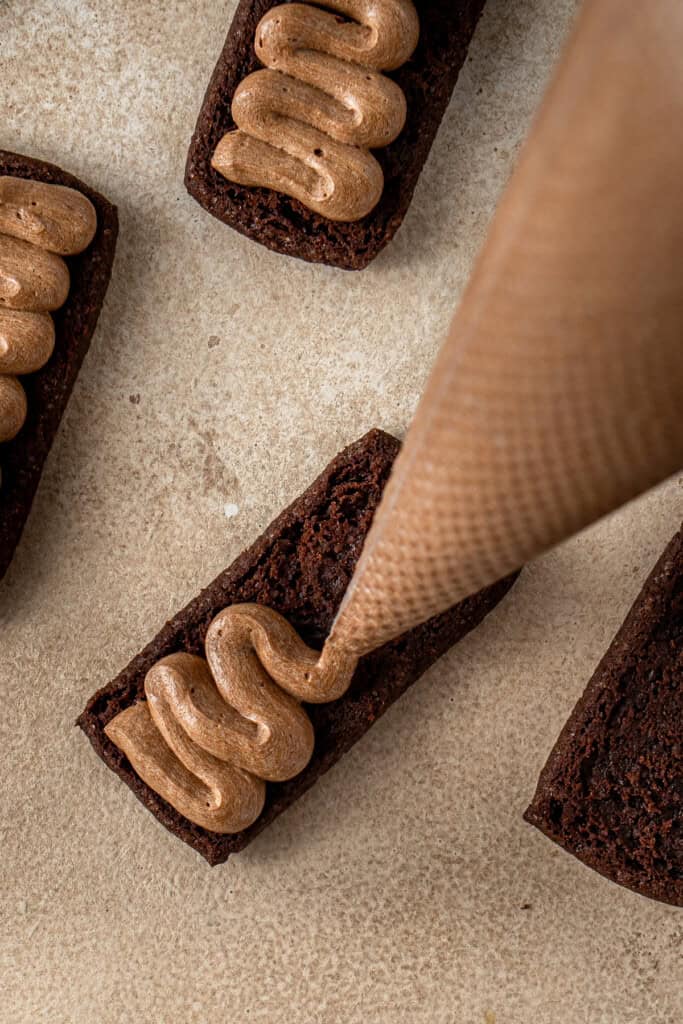 Piping the choc malt filling into the biscuits.