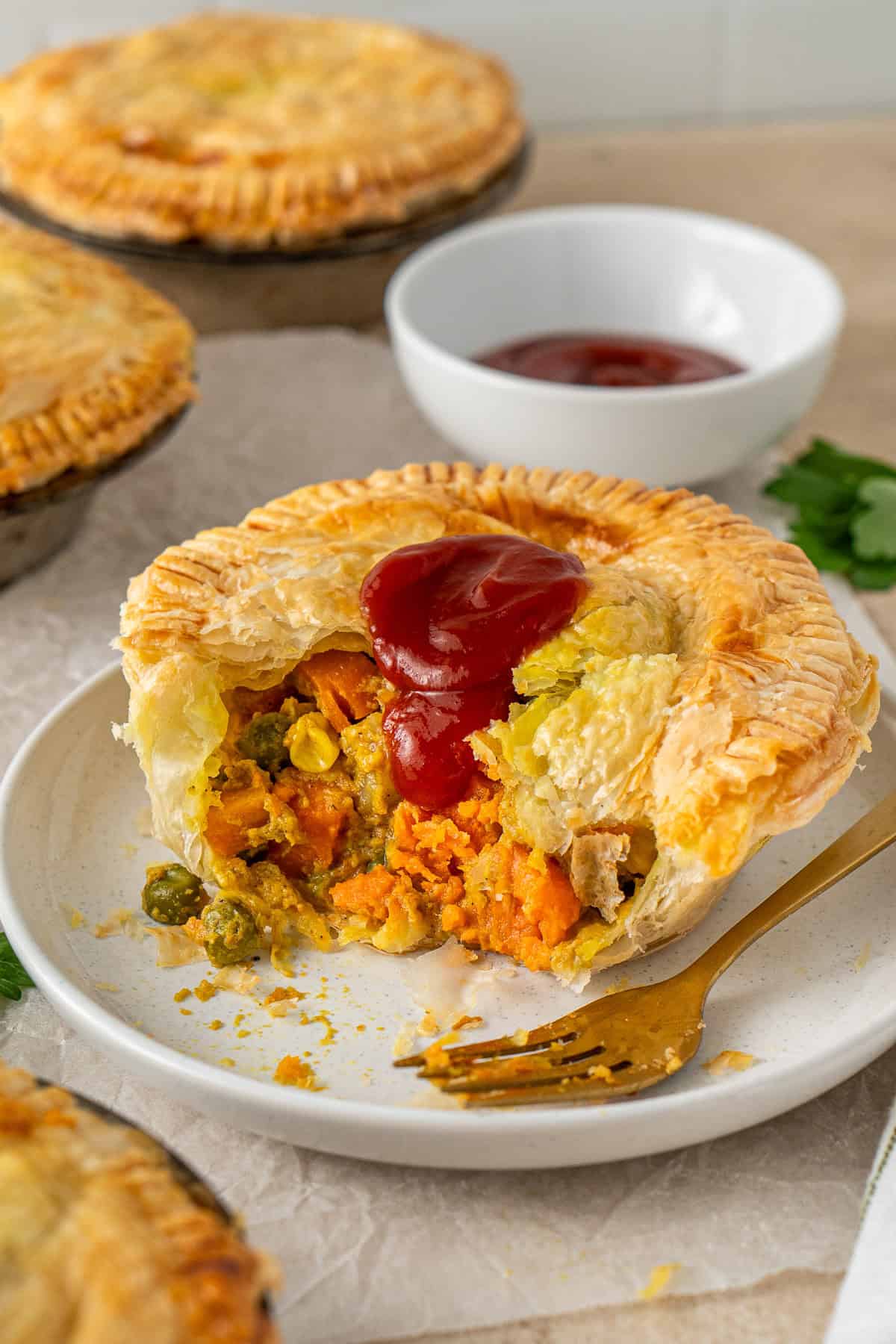 A vegetable curry pie with tomato sauce on a plate with a fork.