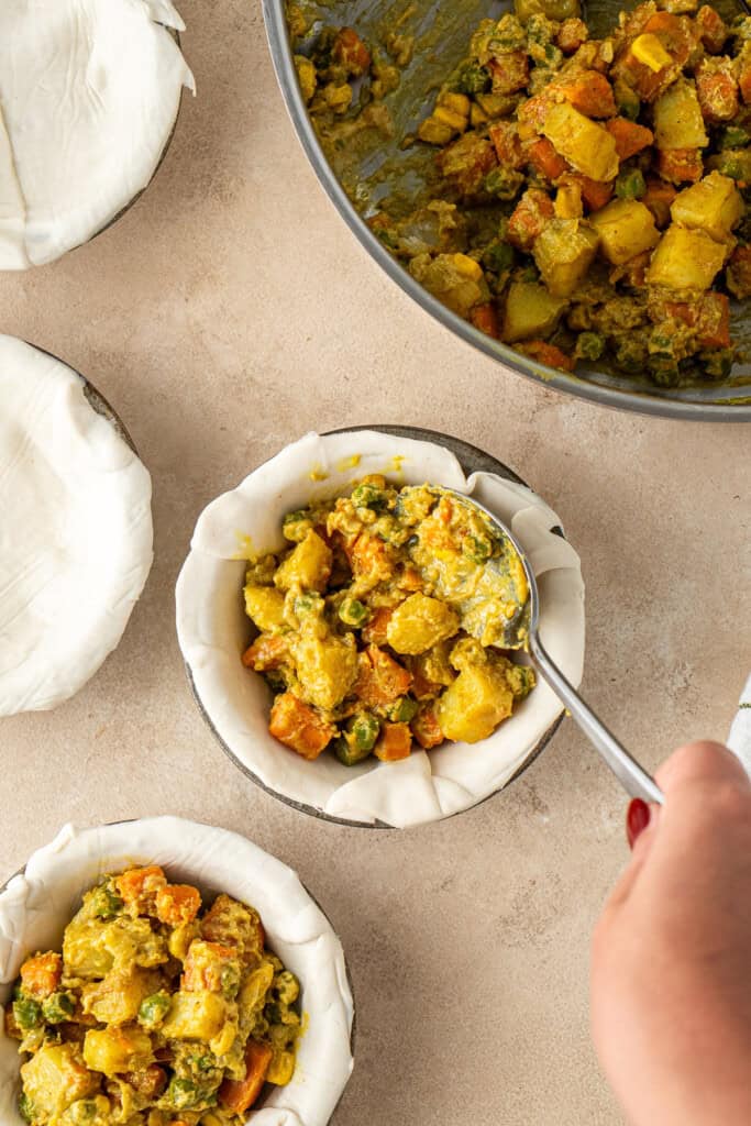 Spooning the filling into the pies.