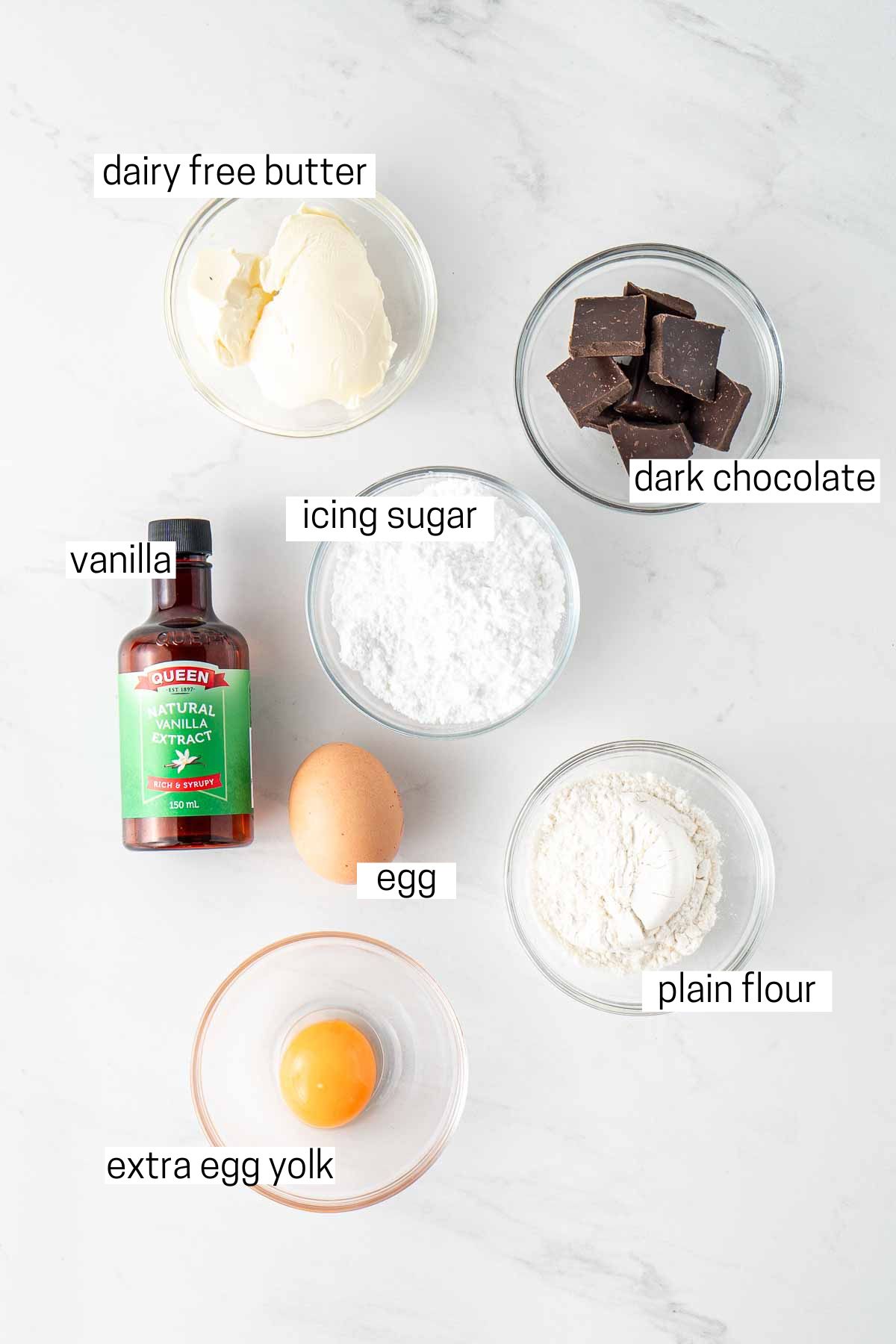 All ingredients needed for chocolate lava cakes laid out in small bowls.