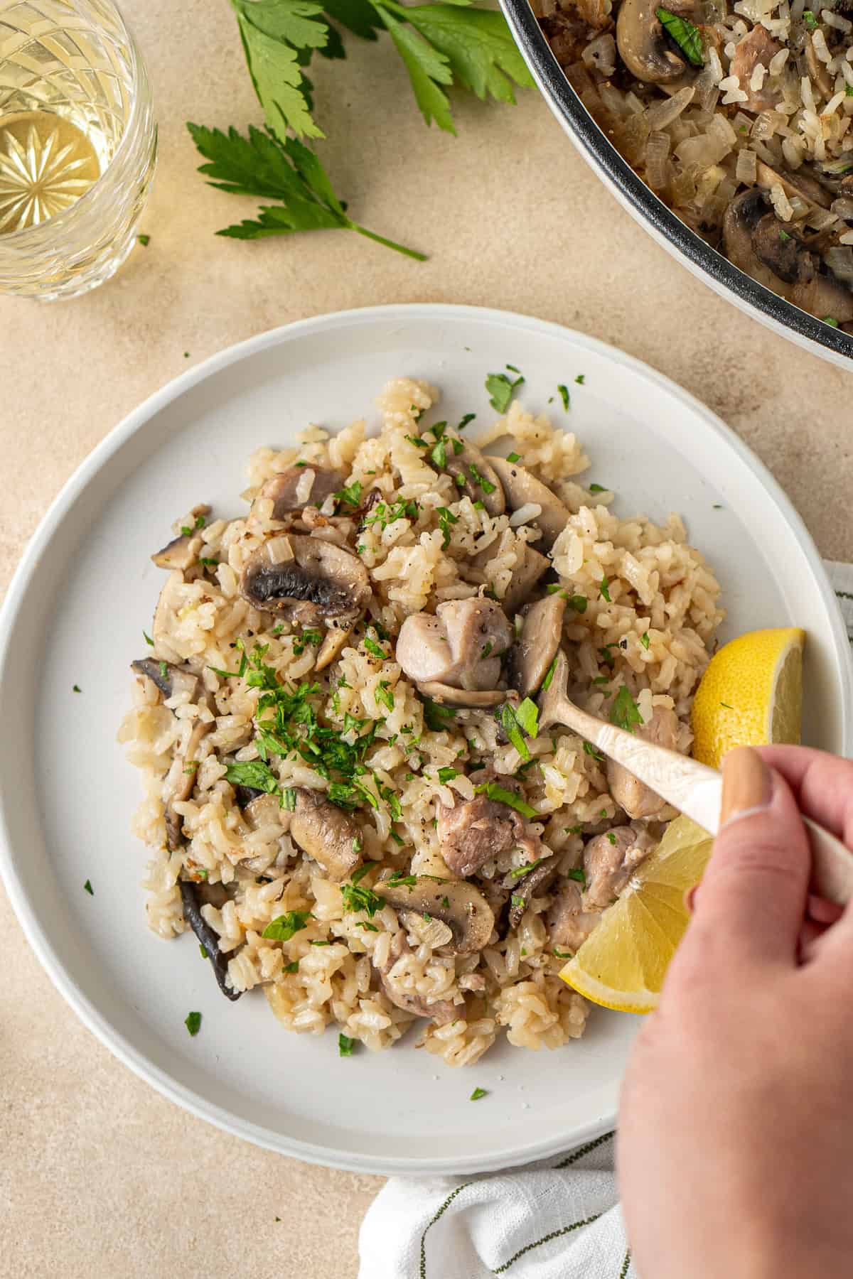 A hand taking a bite of the plated risotto with a fork.