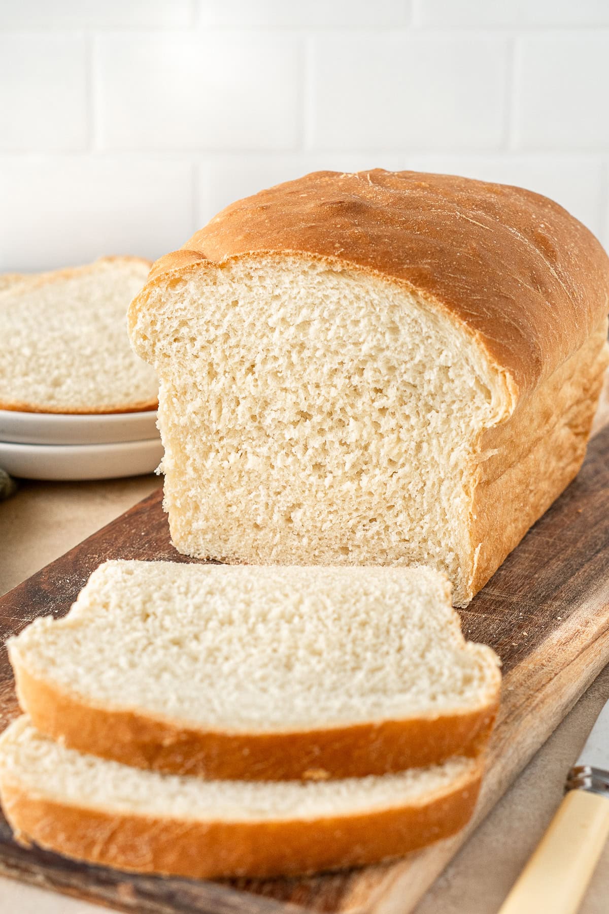 The loaf of sandwich bread being sliced.