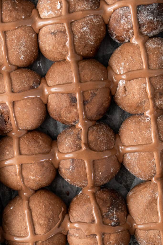 The buns after the second rise with piped crosses.