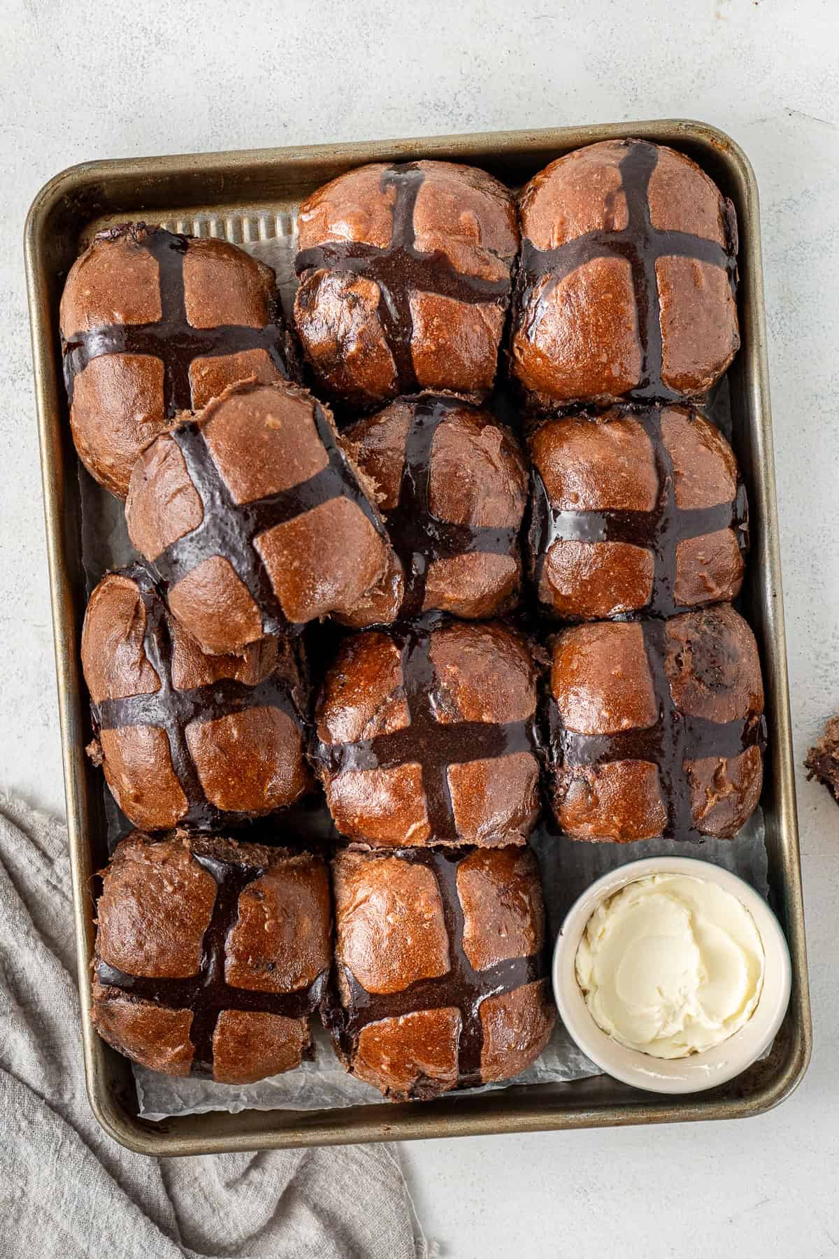 Chocolate hot cross buns in a tray with dairy free butter.