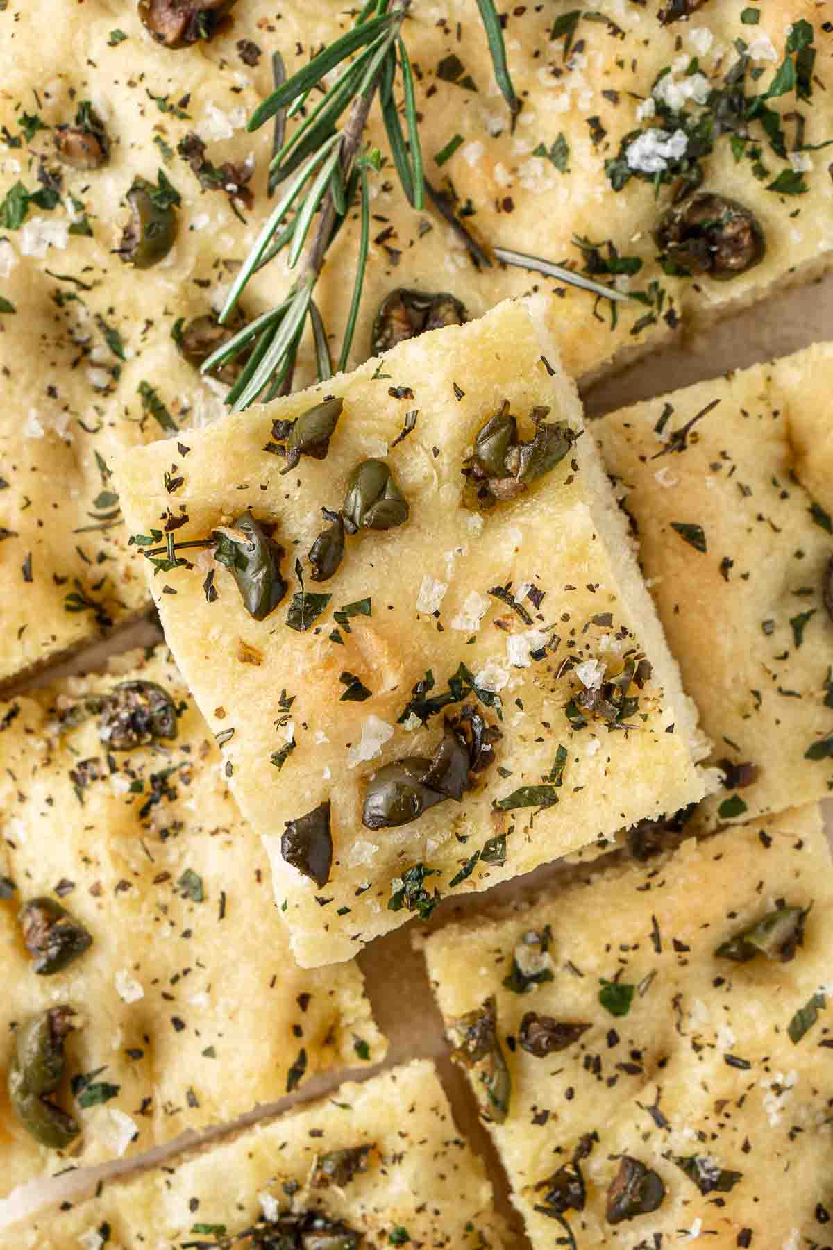Close up of slices of olive and herb focaccia. 