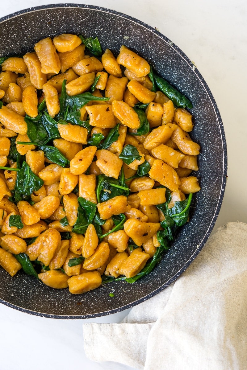 Frying sweet potato gnocchi in a pan with garlic oil