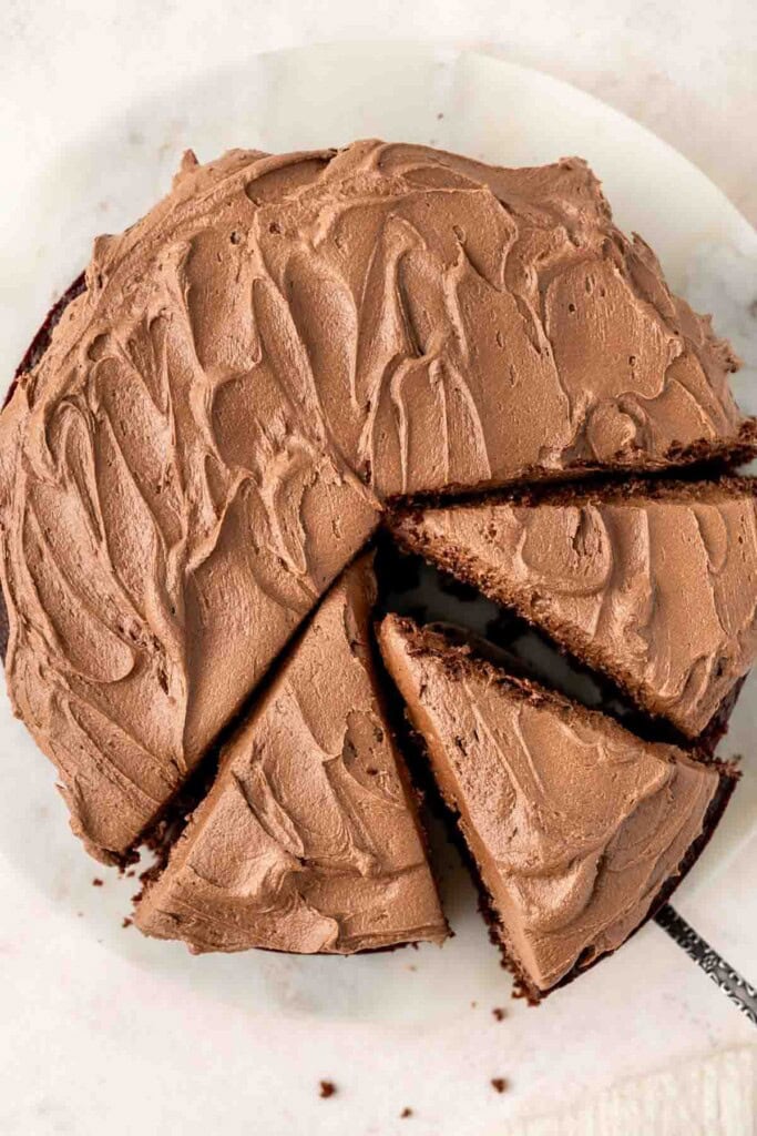 Vegan chocolate cake with buttercream frosting from above cut into slices.