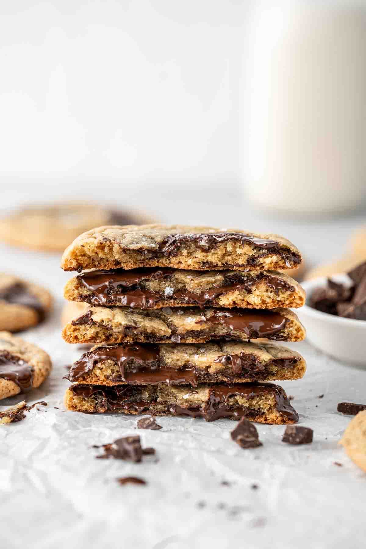 Stack of chocolate chip cookies in half with melting chocolate.