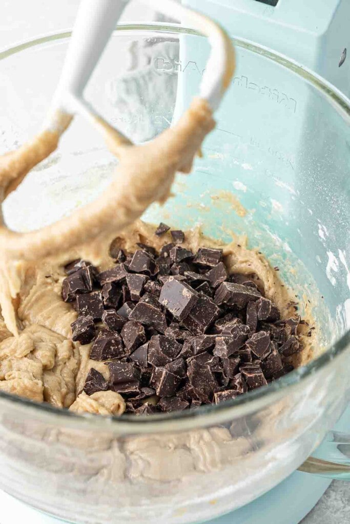 Adding the chocolate to the cookie dough in the stand mixer.