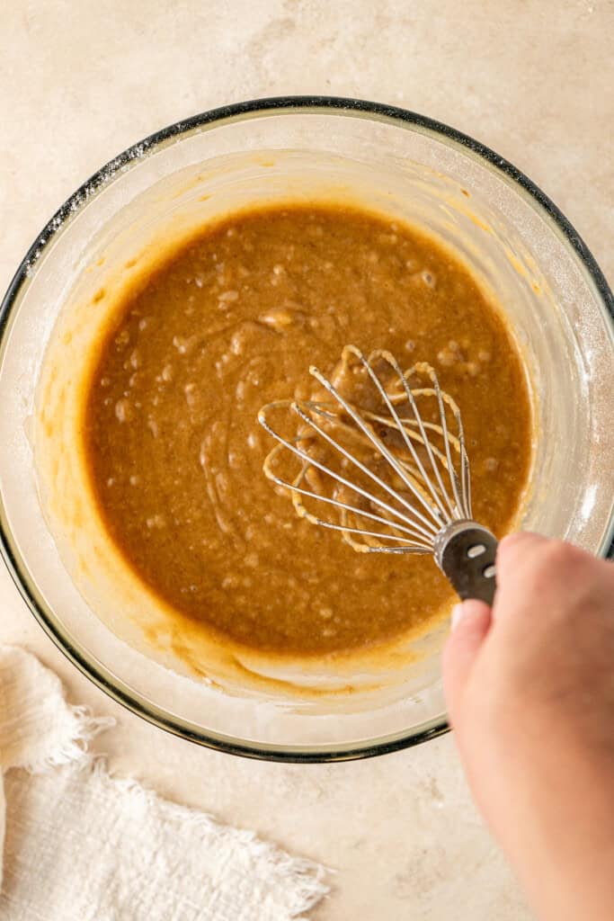 Whisking in the dry ingredients to the wet in a glass bowl.