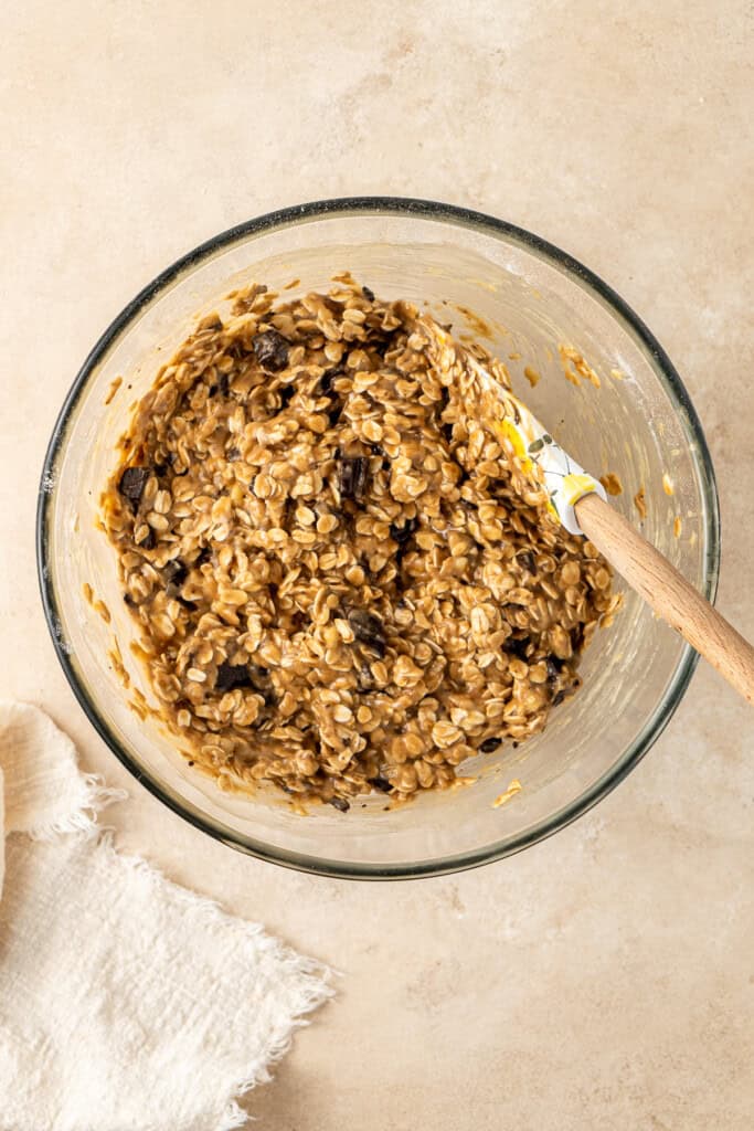 The cookie dough in a glass bowl with a spatula. 