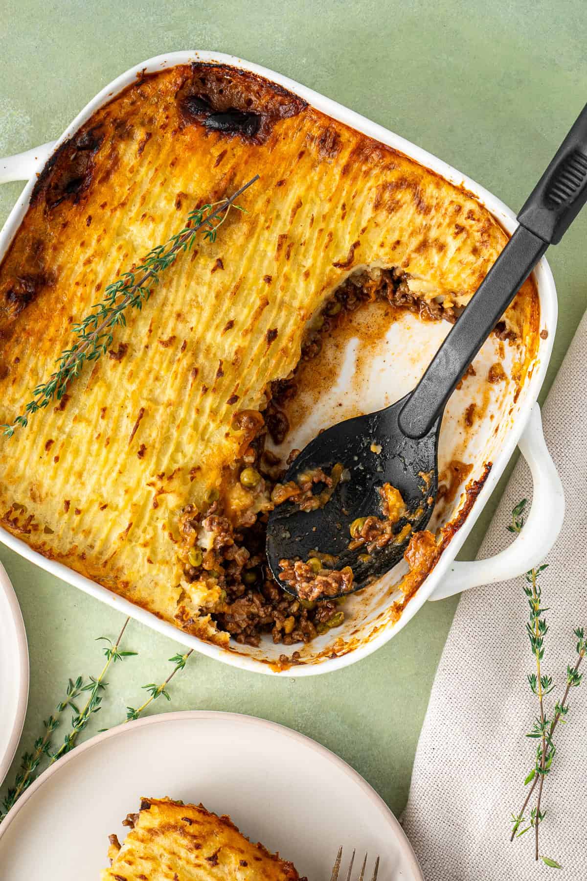 The cottage pie with a large serving spoon.