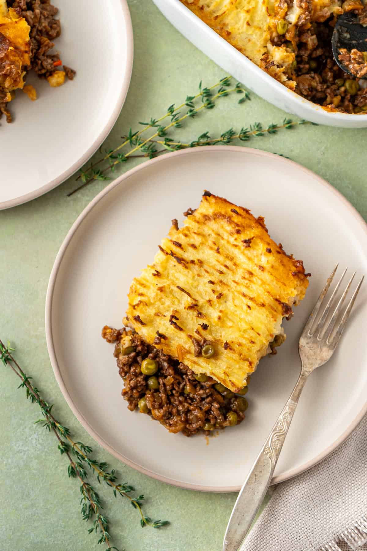 A piece of cottage pie served on a plate with a fork.