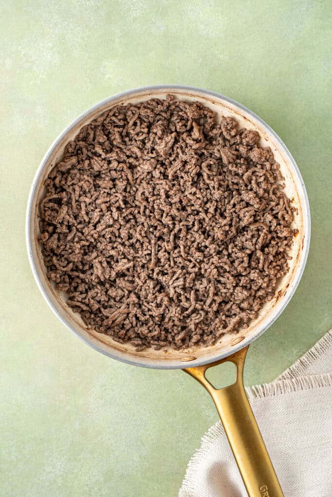 Browning the mince in a frying pan.