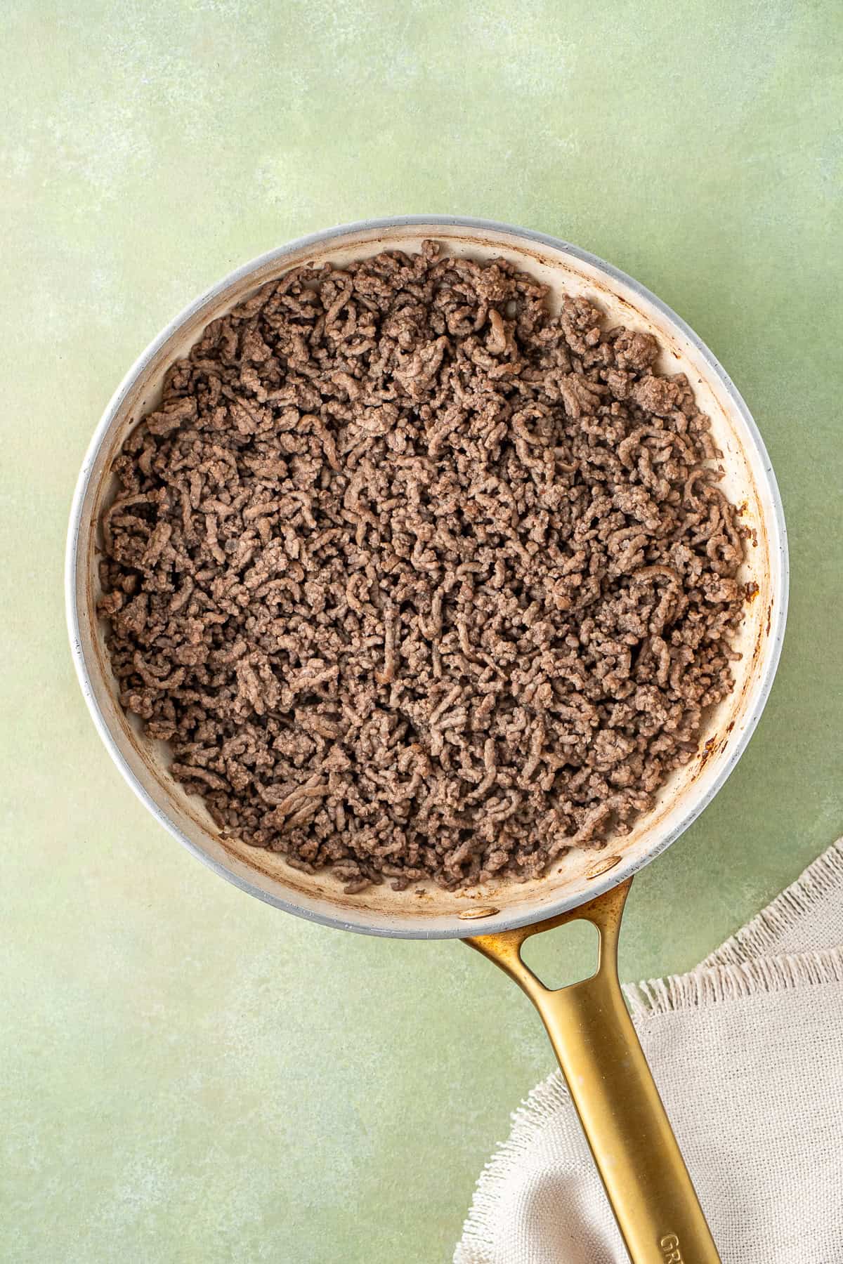 Browning the mince in a frying pan.