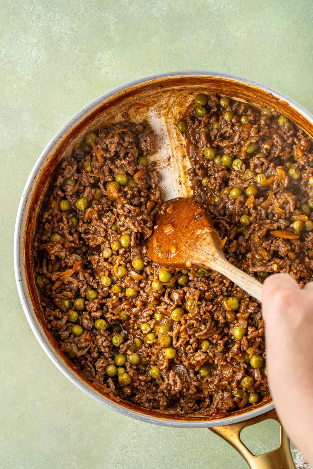 A wooden spoon showing the consistency of the mince mixture.