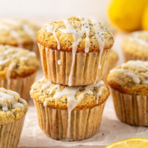 Two dairy free poppy seed muffins stacked on top of each other.