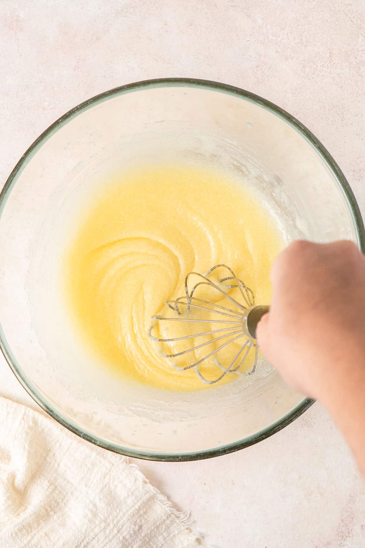 Whisking together the wet ingredients in a glass bowl.