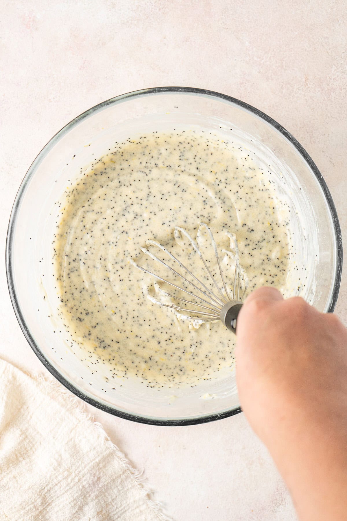 Whisking together the muffin batter in a glass bowl.
