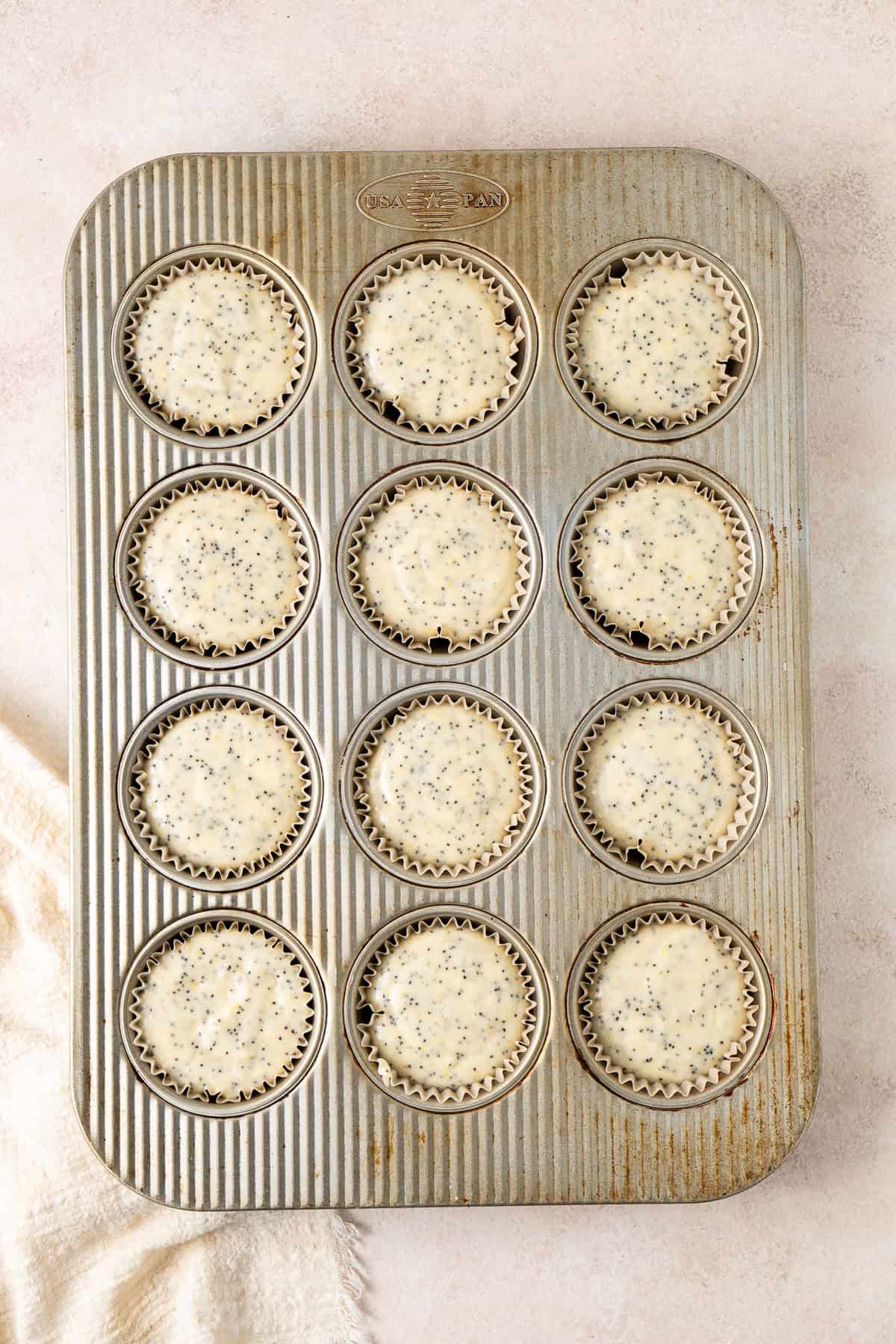 The muffin batter in a 12 cup baking pan.