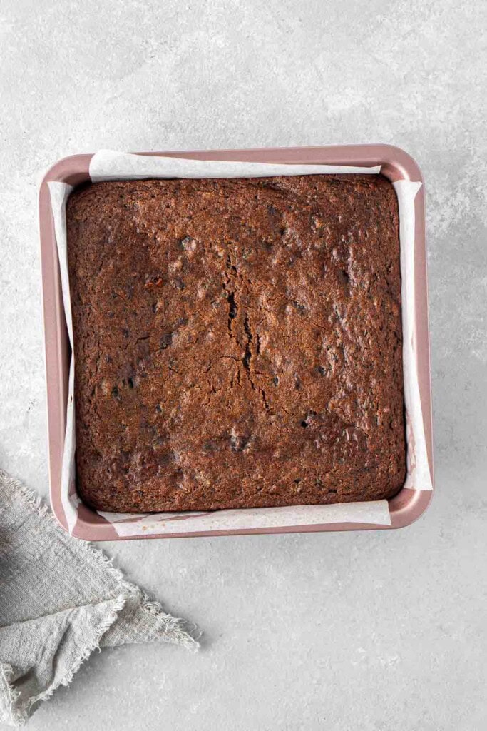 Cooked sticky date pudding in square baking tray.