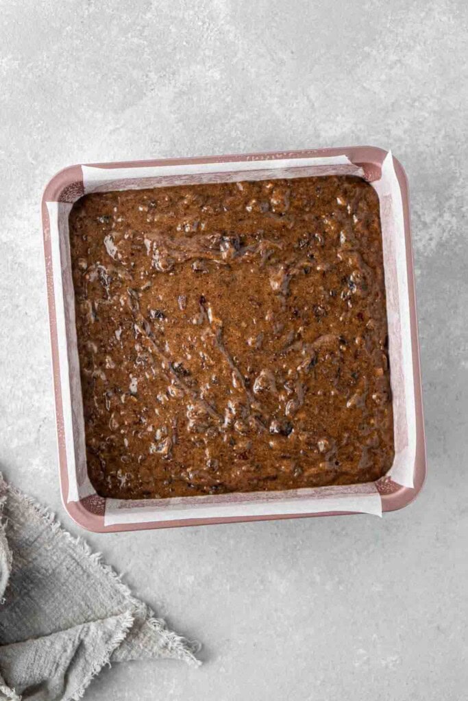 The sticky date pudding batter in a square baking tray.