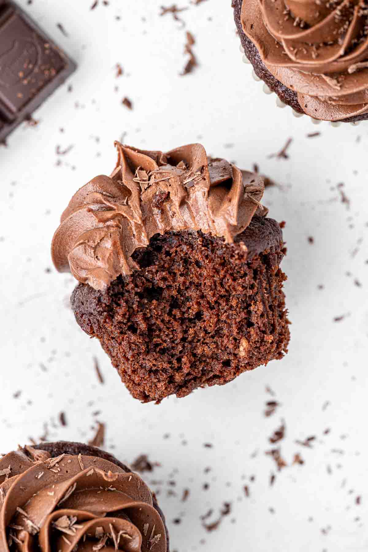 Overhead shot of a vegan chocolate cupcake with a bite taken.