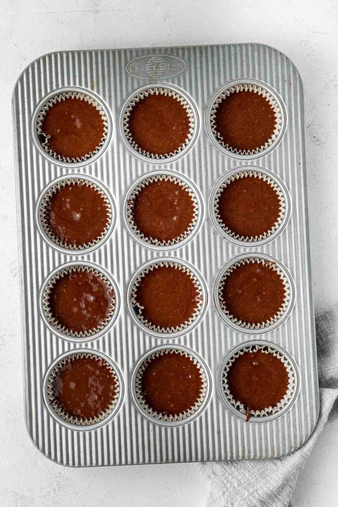 Chocolate cupcake batter in a muffin pan.