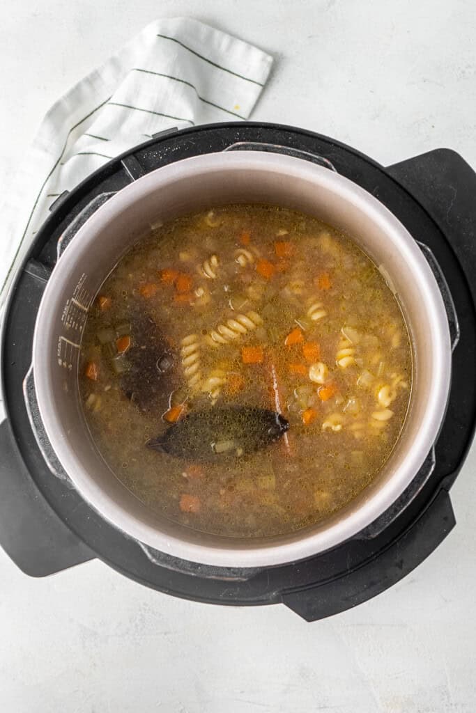 Boiling the pasta in the broth in the pressure cooker.
