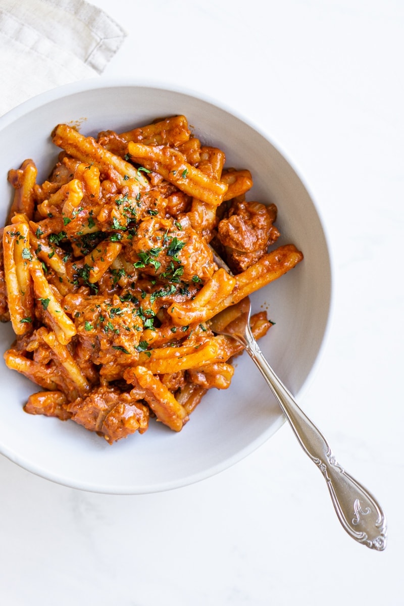 Spicy tomato pasta with fork in a bowl