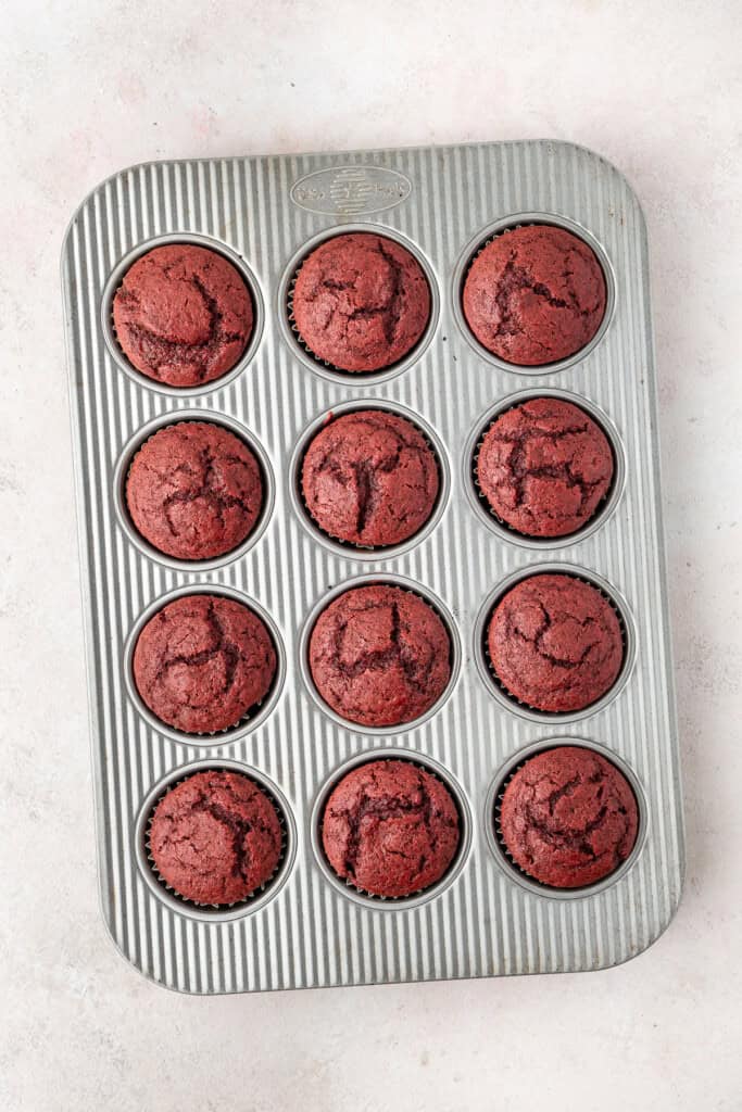 The cooked red velvet cupcakes in a muffin pan.