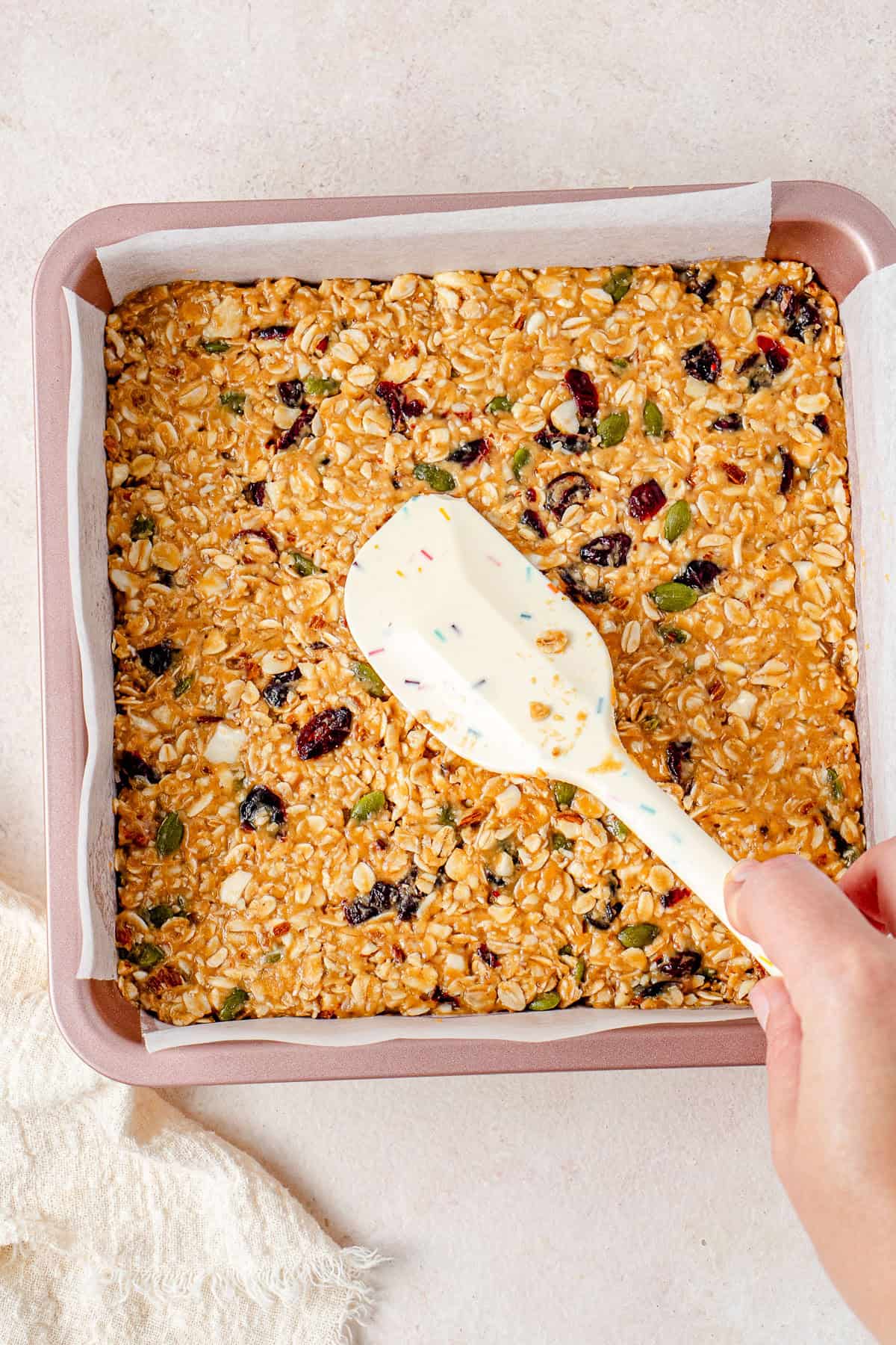 Pressing the mixture into a square pan.