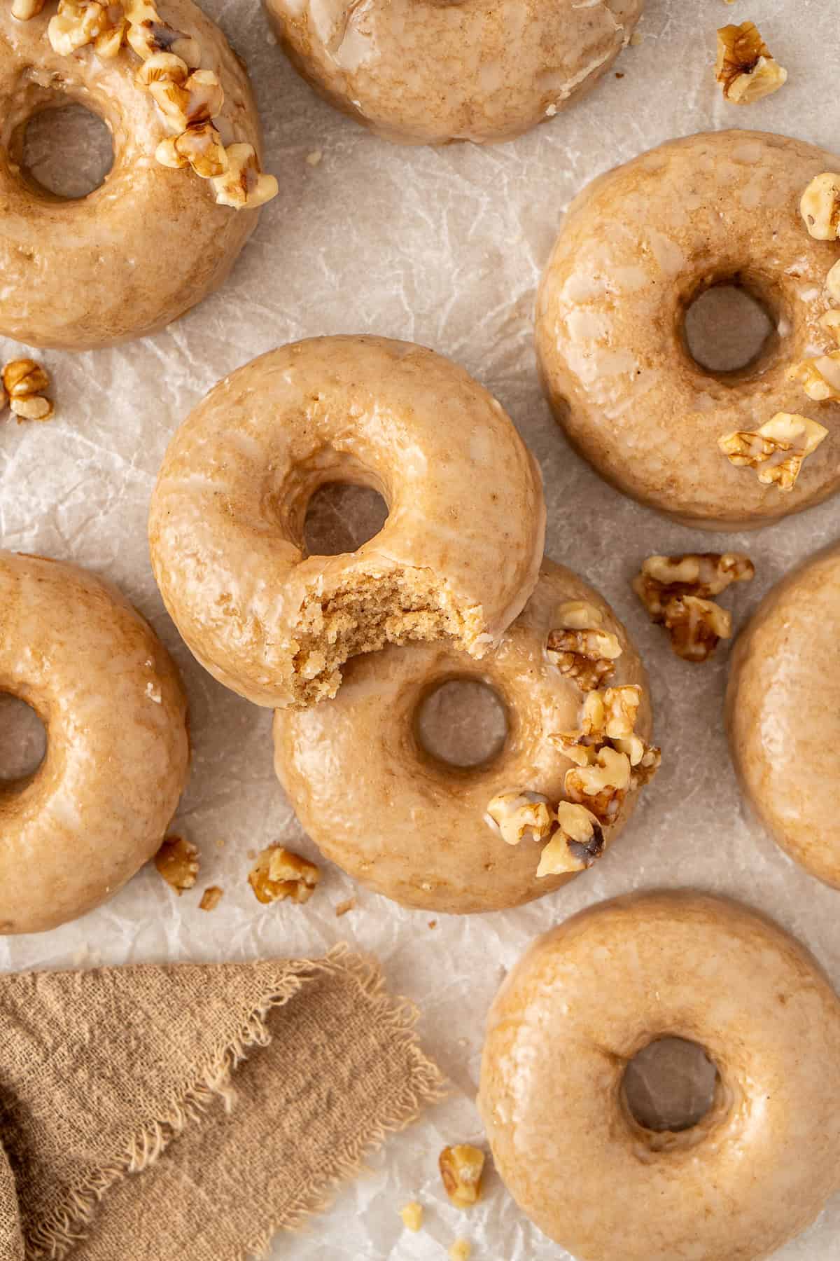 Maple glazed doughnuts laid out, one with a bite taken.