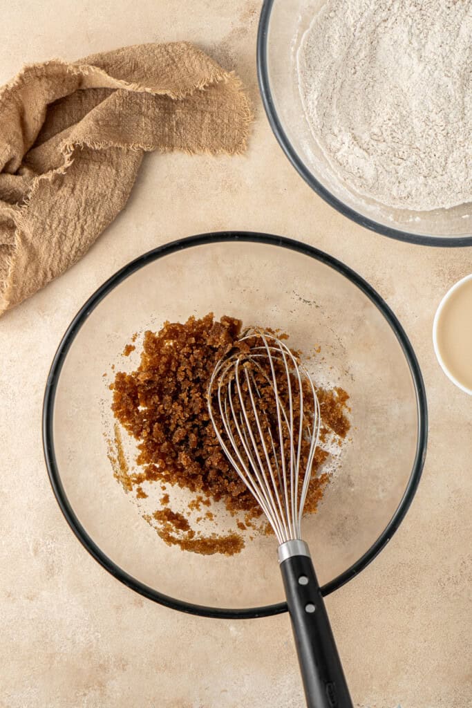 Whisking the brown sugar and canola oil in a bowl.