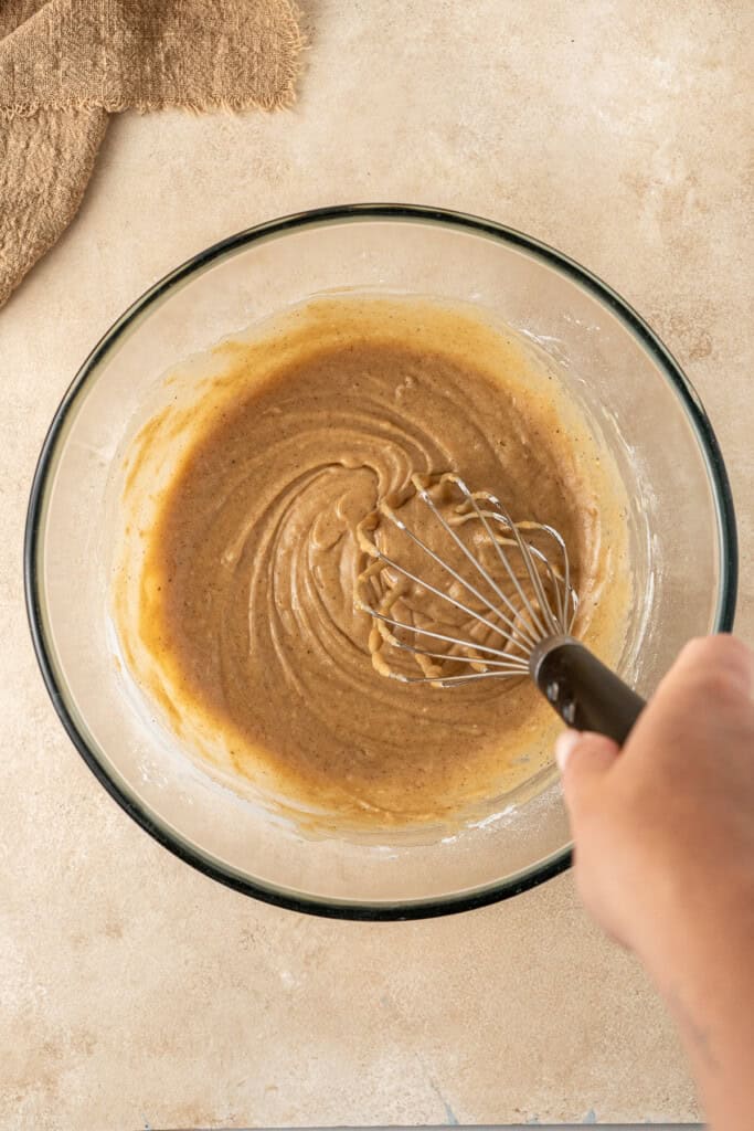 Whisking together the doughnut batter in a bowl.