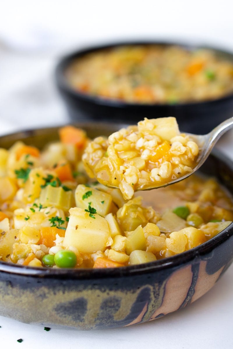 Spoon full of hearty barley and vegetable soup