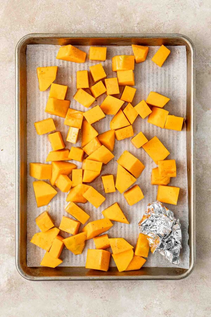 Pumpkin cubes on a baking tray.