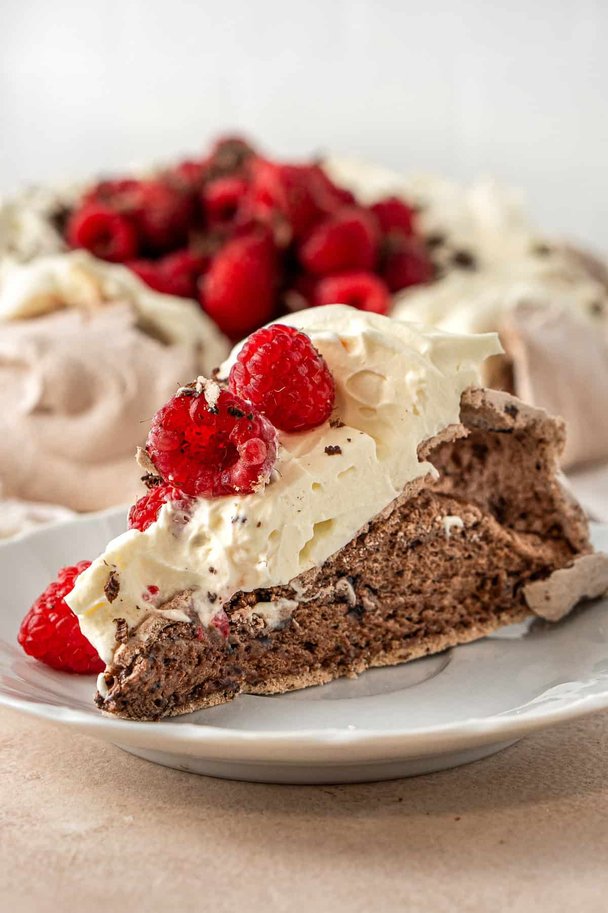Close up of a slice of chocolate pavlova with a marshmallow centre.