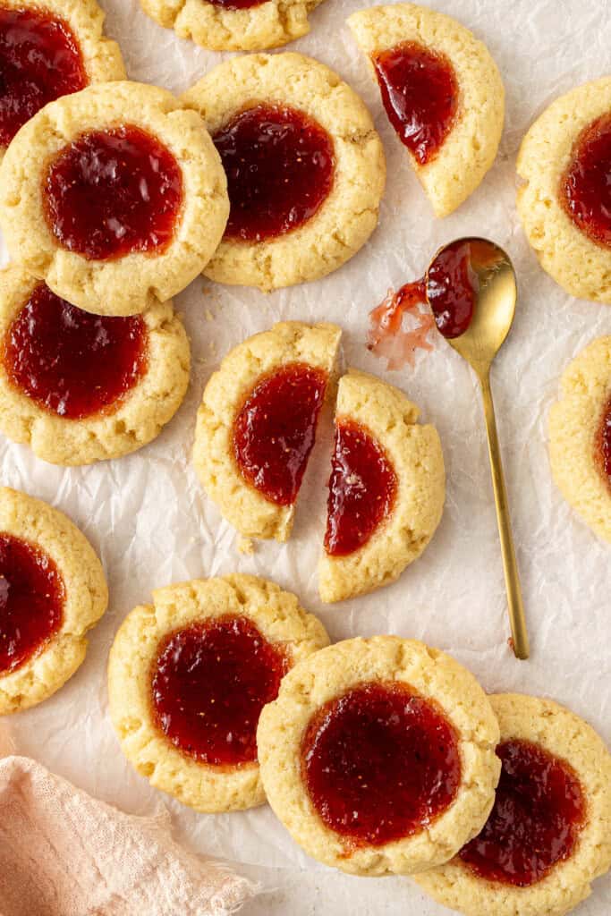 Strawberry thumbprint cookies with one broken in half.