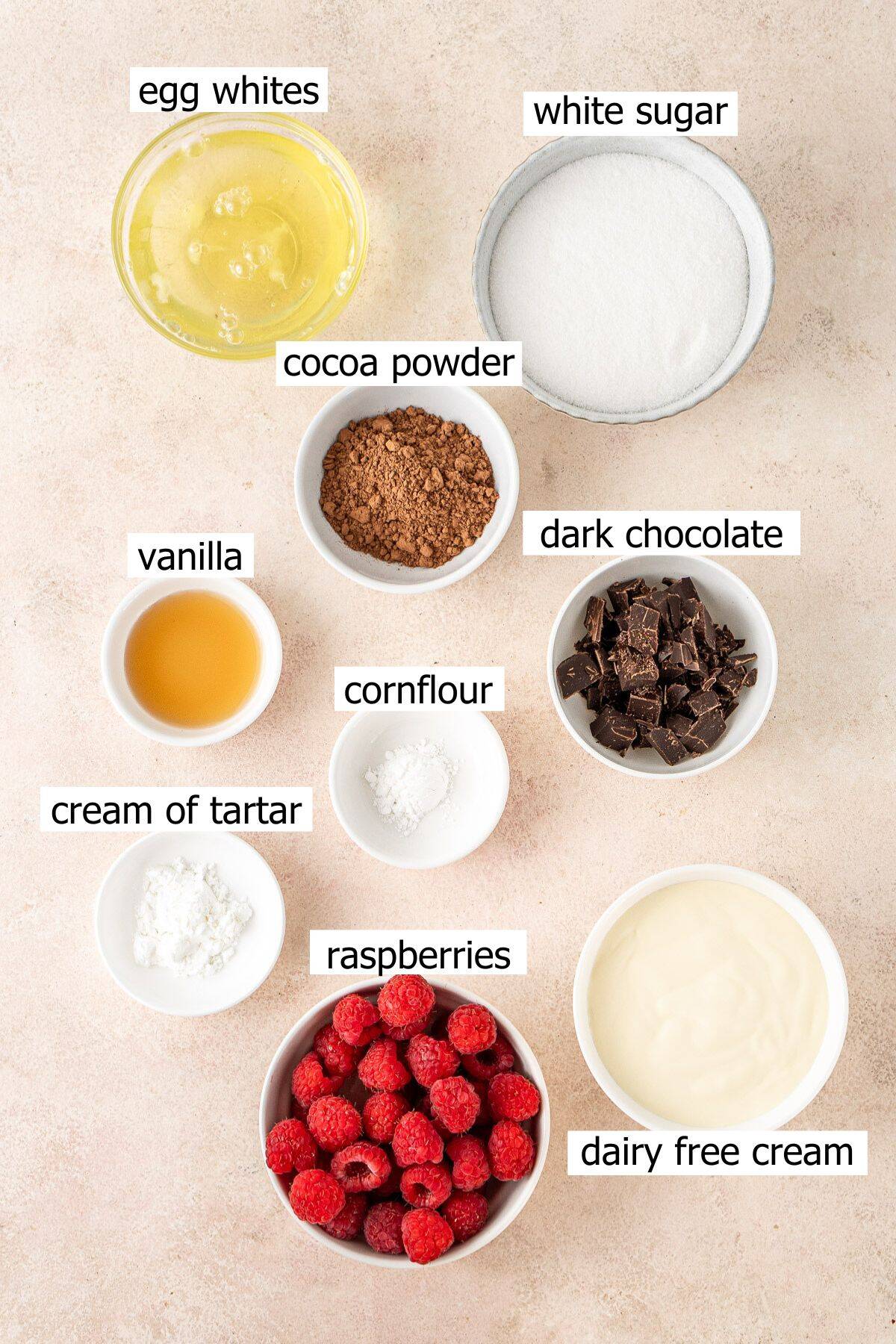 All ingredients needed to make chocolate pavlova laid out in small bowls.