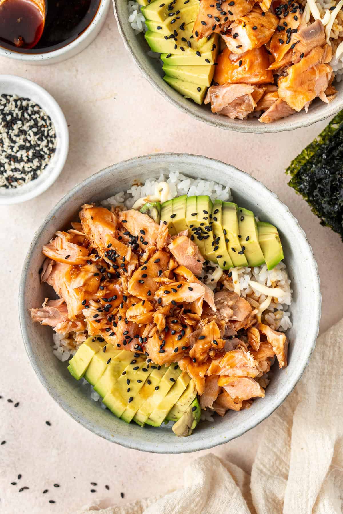 A close up of the salmon and avocado rice bowls with black sesame seeds.