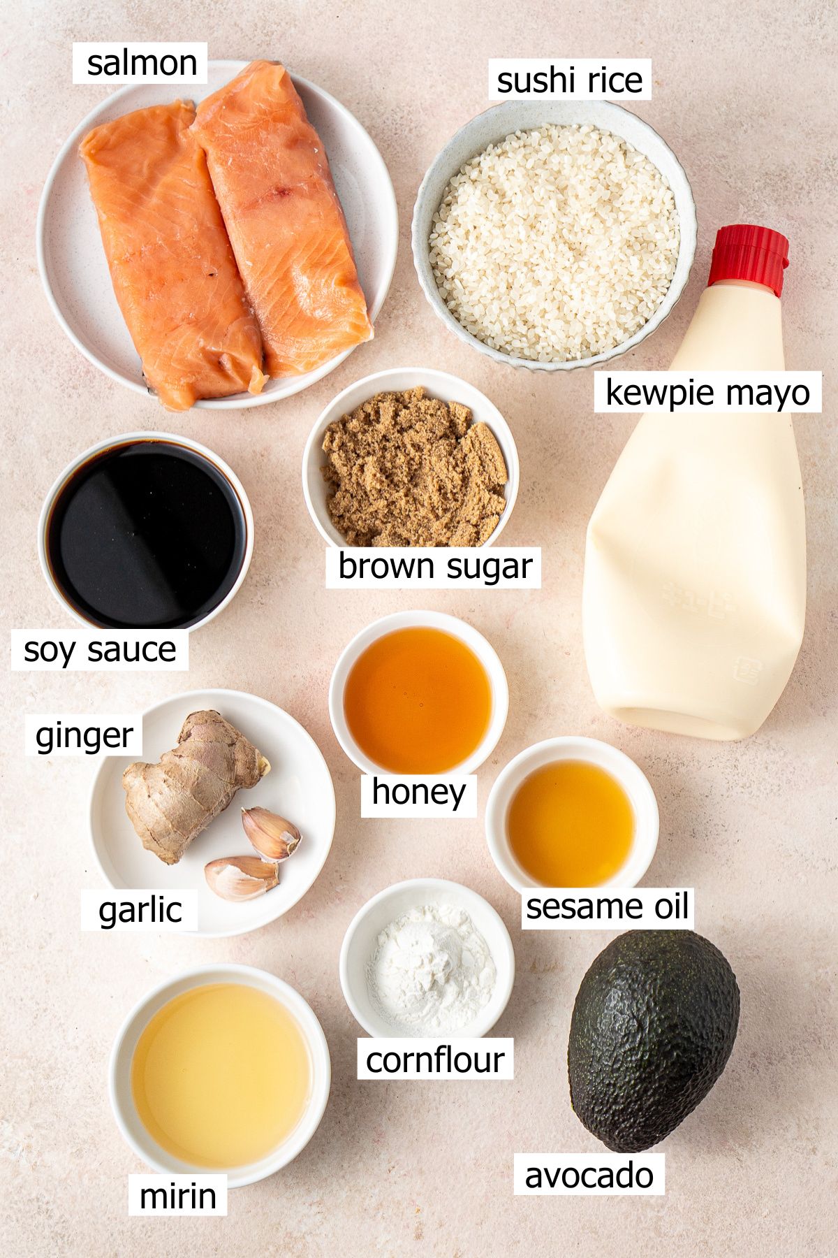 All ingredients to make salmon and avocado rice bowls with homemade teriyaki sauce laid out in small bowls.