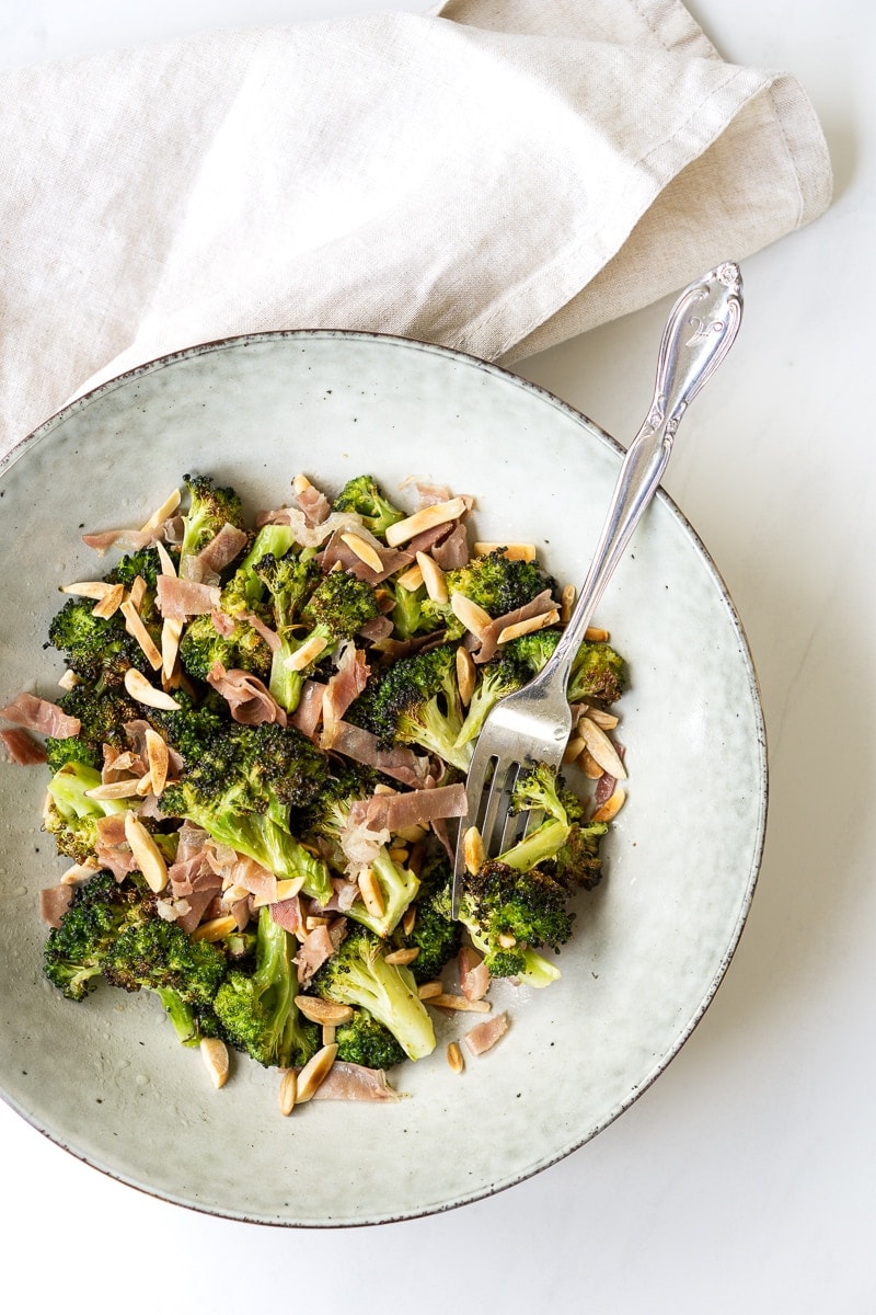 Broccoli salad in a bowl with prosciutto and almonds