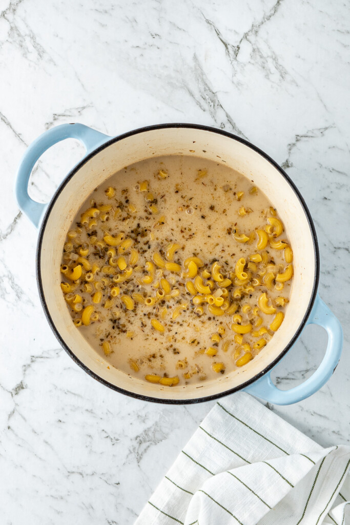 The liquids and pasta in the pot.