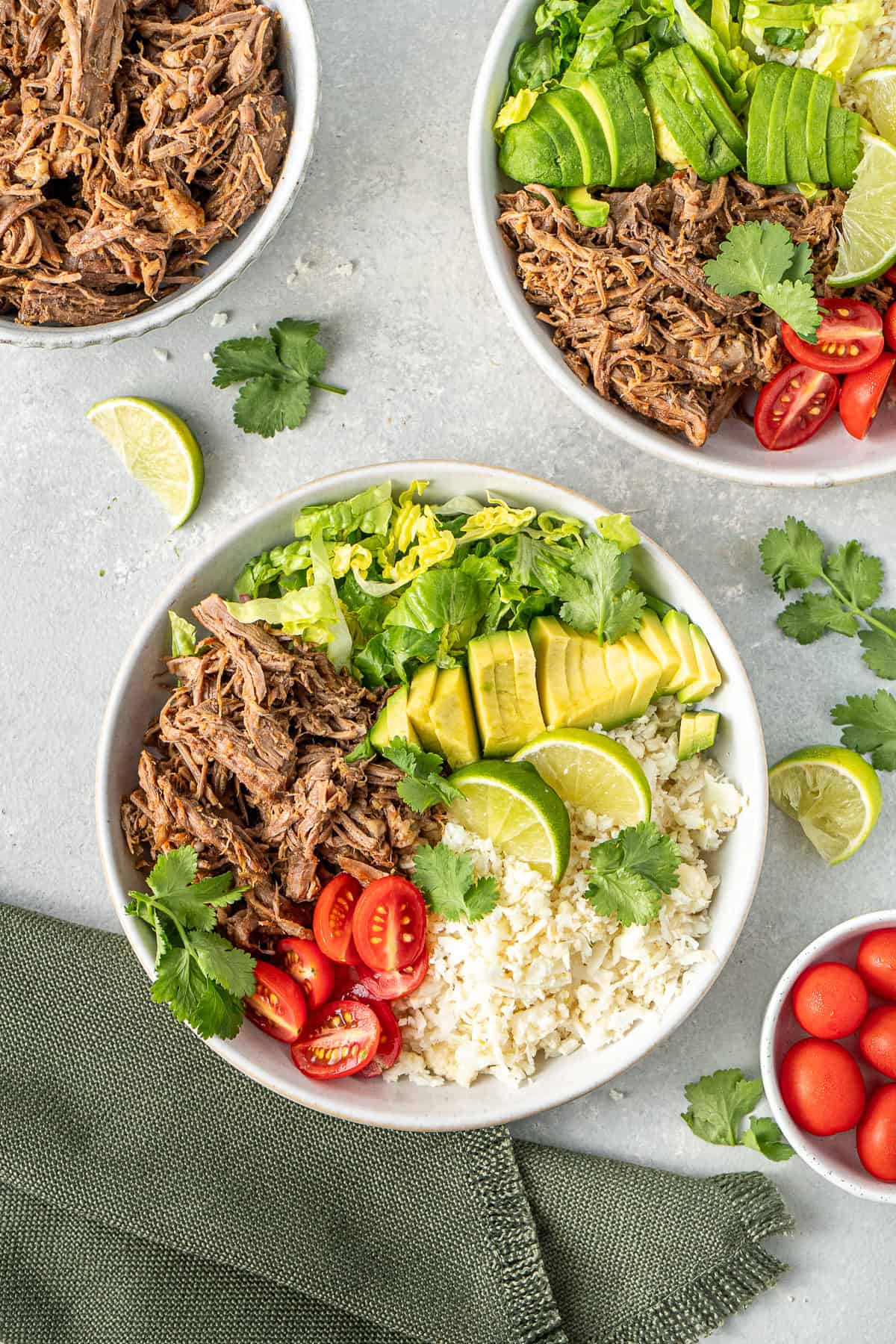 Whole30 beef burrito bowls served with avocado, tomato, lettuce and coriander. 
