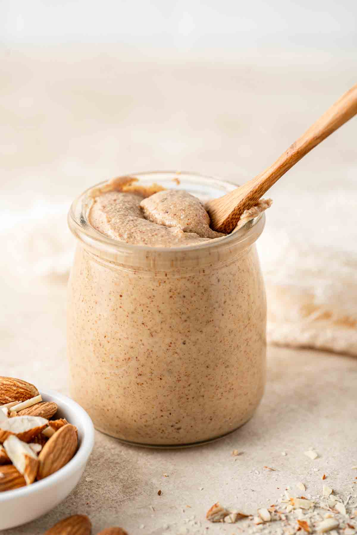 Almond butter in a jar with a spoon.